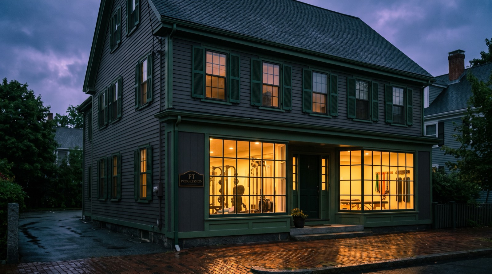 Historic New England home converted to a modern physical therapy studio, glowing at dusk